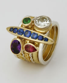 'Stacking Ring' in 18K yellow and white gold with lozenge shaped bridge feature set with seven round blue Sapphires